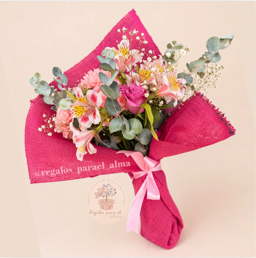 Ramo de flores en tonos rosa, envuelto en papel fucsia y con tarjeta de la marca